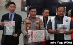 Atase Polisi Kedutaan Besar Jepang di Indonesia, Takayugi Miyagawa (kiri) bersama Karopenmas Polri, Ahmad Ramadhan (tengah) dan DirtipidSiber Polri, Adi Vivid (kanan) menunjukkan barang bukti yang disita berupa piranti lunak komputer dan HP dari tangan tersangka pelaku peretasan kartu kredit yang memakan korban delapan orang warga negara Jepang. (VOA/Indra Yoga)