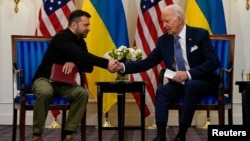 El presidente de Estados Unidos, Joe Biden, estrecha la mano del presidente ucraniano, Volodymyr Zelenskiy, en París, Francia, el 7 de junio de 2024. REUTERS/Elizabeth Frantz