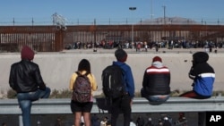 Foto Achiv: Migran veye moun pandan yo kanpe bo kote miray ki separe fwontye Etazini ak Meksik nan vil Ciudad Juarez, Meksik, 21 Dec. 2022. 