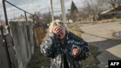 Реакция местной жительницы на звуки артиллерийской стрельбы рядом с ее домом в населенном пункте Часов Яр, недалеко от города Бахмут, Украина. 4 марта 2023 года.