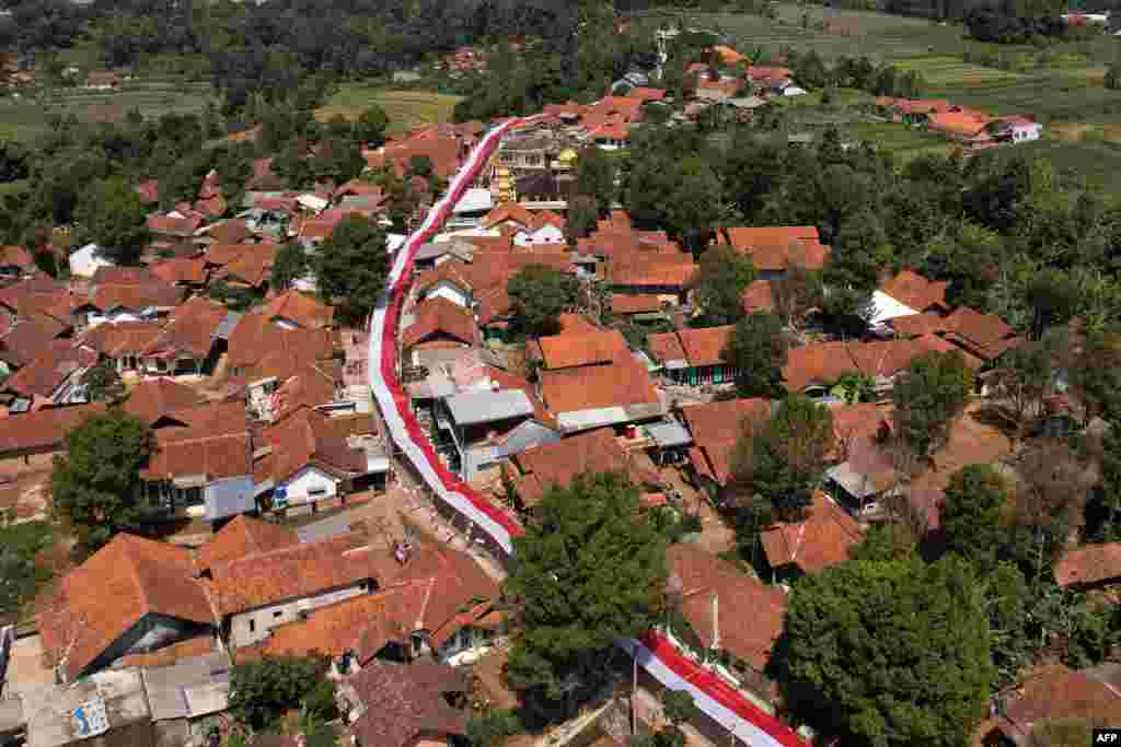 Foto udara menunjukkan kain merah putih sepanjang 1.000 meter digelar di sepanjang jalan di Lemahsugih, Jawa Barat, menjelang perayaan HUT Kemerdekaan RI ke-79. (Foto: Timur Matahari / AFP)&nbsp;