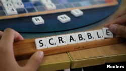 FILE - A player forms the word "Scrabble" with tiles during a practice session, in this posed picture taken in Kuala Lumpur, Malaysia, Nov. 30, 2019.