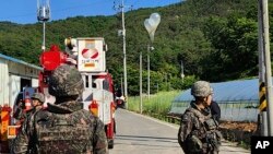 FILE - Balon berisi sampah yang diduga dikirim oleh Korea Utara, tergantung di kabel listrik saat tentara Korea Selatan berjaga di Muju, Korea Selatan, Rabu, 29 Mei 2024. (Markas Besar Pemadam Kebakaran Jeonbuk via AP)