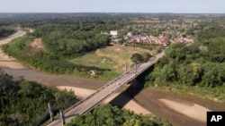 FILE - The Integration border bridge connects Assis, Brazil, left, and Inapari, Peru, June 20, 2024. Brazil will begin imposing restrictions on the entry of some foreigners from Asia who use Brazil as a launching point to migrate to the United States and Canada.