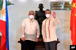 Menteri Luar Negeri Filipina Enrique Manalo, kiri, dan Menteri Luar Negeri China Wang Yi di Departemen Luar Negeri di Manila, Filipina pada 6 Juli 2022. (Foto: via AP)