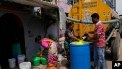 Residents of Ambedkar Nagar, a low-income settlement, collect potable water from a private tanker in Bengaluru, India, March 11, 2024. Water levels are running desperately low, particularly in poorer regions, resulting in sky-high costs for water and a quickly dwindling supply. 