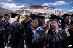 资料照片：2021年6月1日，政府组织外国记者参观期间，西藏大学的毕业生准备在拉萨布达拉宫广场上合影。
