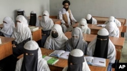 FILE - Young girls attend a religious school in Kabul, Afghanistan, on Aug. 11, 2022. Afghanistan is the only country in the world that prohibits girls ages 12 and older from attending secondary school.