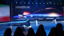 Women look at a Fattah missile in a ceremony in Tehran, Iran, June 6, 2023. Iran is claiming that it's created a hypersonic missile capable of traveling at 15 times the speed of sound. 