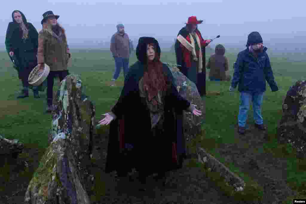 People celebrate the arrival of Spring Equinox on top of Sliabh na Caillaigh at dawn to watch the sunrise over the ancient Loughcrew megalithic cairns, in Oldcastle, Ireland.