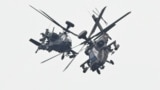 Two U.S.-made Apache attack helicopters, from Taiwan's Army Airborne Special Forces, demonstrate their combat skills during a military open house event in Hsinchu, Taiwan, Sept. 21, 2023. 