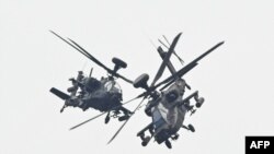 Two U.S.-made Apache attack helicopters, from Taiwan&#39;s Army Airborne Special Forces, demonstrate their combat skills during a military open house event in Hsinchu, Taiwan.