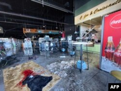 Noda darah terlihat di tanah di mana seorang penduduk setempat terbunuh di sebuah hypermarket di kota Kherson, Ukraina selatan, di tengah invasi Rusia ke Ukraina. (Dina Pletenchuk / AFP)