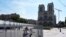 People watch Notre Dame cathedral from outside the security zone set up for the Olympic Games in Paris, July 18, 2024. 