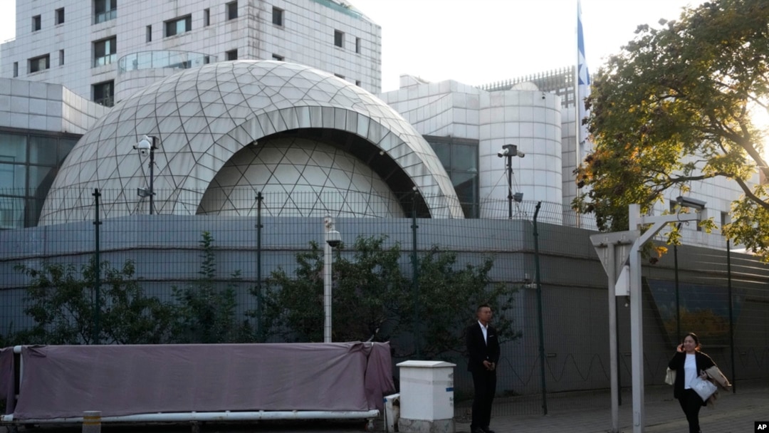 A plainclothes security person stands watch outside the Israeli Embassy in Beijing, Oct. 13, 2023. 