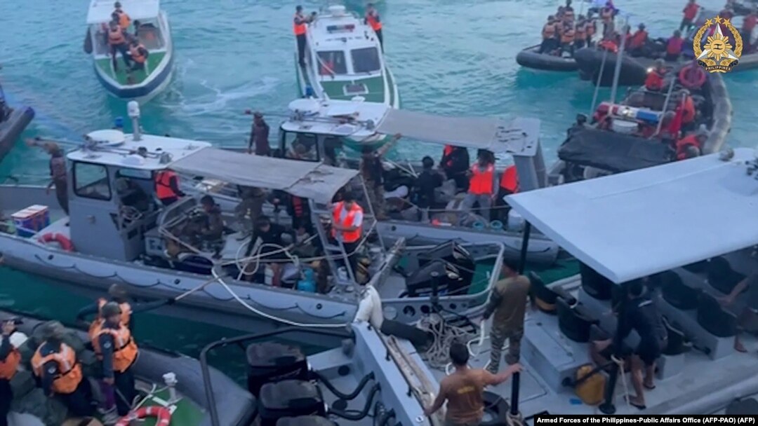Personel Garda Pantai China (kiri, kanan) menghalangi kapal Angkatan Laut Filipina (tengah) selama konfrontasi di Second Thomas Shoal di Laut Cina Selatan. (Foto: AFP)