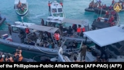 This screengrab taken from a handout video filmed on June 17, 2024 shows Chinese coast guard personnel (L,R) aboard their inflatable boats blocking Philippine navy boats (C) during a confrontation at the Second Thomas Shoal in the South China Sea.