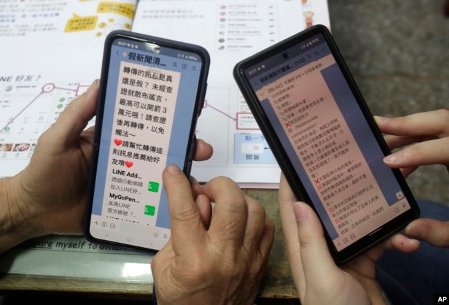 Volunteers of Fake News Cleaner guide students through the LINE app to identify fake news during a class in Kaohsiung City, southern Taiwan, Thursday, March 16, 2023. (AP Photo/Chiang Ying-ying)