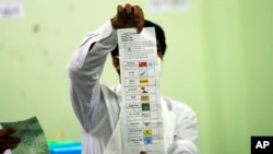FILE - An official of the Union Election Commission counts ballots at a polling station in Naypyitaw, Myanmar, Nov. 8, 2020. 