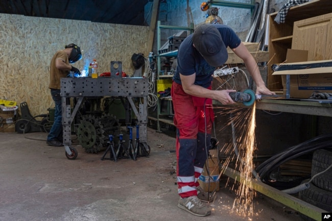 Engineers of design and production bureau "UkrPrototyp" work on new parts for a ground drone, in northern Ukraine, Thursday, June 27, 2024. (AP Photo/Anton Shtuka)