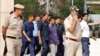 Police officers escort Chief Minister of Delhi and Aam Aadmi Party (AAP) Arvind Kejriwal as he leaves the court after a hearing in New Delhi, March 28, 2024. 