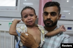 Ammar Al-Mashhrawi, seorang anak laki-laki Palestina yang menderita infeksi kulit, digendong ayahnya, Ahmed, di sebuah rumah sakit di Jabalia, Jalur Gaza utara, 5 Agustus 2024. (Mahmoud Issa/REUTERS)