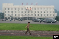 평양 시내에서 한 북한 주민이 '노동신문' 문구가 새겨진 건물 앞을 지나가고 있다.