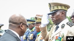 Jenerali Brice Oligui Nguema (Kulia) alipopewa nishani na Waziri Mkuu wa Gabon Alain Claude Bilie Bie Nze (kushoto). Picha na AFP.