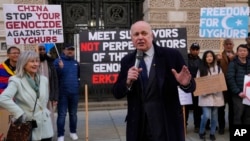 British lawmaker Iain Duncan Smith and human rights campaigner Helena Kennedy, left, join activists and community members as they protest outside the British Foreign Office in central London, Feb. 13, 2023. 