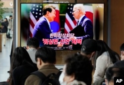 FILE - A TV screen shows an image of U.S. President Joe Biden and South Korean President Yoon Suk Yeol in Washington, during a news program at the Seoul Railway Station in Seoul, South Korea, April 27, 2023.