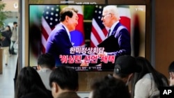 A TV screen shows an image of US President Joe Biden and South Korean President Yoon Suk Yeol in Washington, during a news program at the Seoul Railway Station in Seoul, South Korea, April 27, 2023.