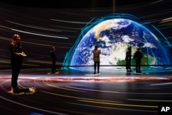 FILE - Visitors take in the Invisible Worlds interactive display during a media preview of the Richard Gilder Center for Science, Education and Innovation, Wednesday, April 26, 2023, at the American Museum of Natural History in New York. The Gilder Center opens to the public May 4. (AP Photo/Mary Altaffer)