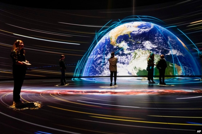 FILE - Visitors take in the Invisible Worlds interactive display during a media preview of the Richard Gilder Center for Science, Education and Innovation, Wednesday, April 26, 2023, at the American Museum of Natural History in New York. The Gilder Center opens to the public May 4. (AP Photo/Mary Altaffer)