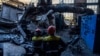 Workers stand among debris in a damaged DTEK thermal power plant after a Russian attack in Ukraine, May 2, 2024.