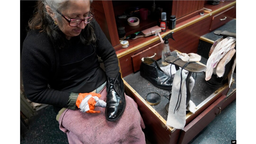 Bertha Gomez menyemir sepatu pelanggan di Alpha Shoe Repair Corp. di New York, 3 Februari 2023. Jasa semir sepatu kini menjadi lebih langka, dan banyak stan telah menghilang di seluruh AS. (AP / Mary Altaffer)
