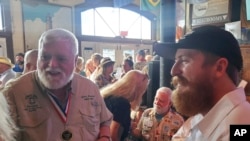 Stephen Hemingway Adams, right, a great-grandson of Ernest Hemingway, speaks with 2023 Hemingway Look-Alike Contest winner Gerrit Marshall at Sloppy Joe's Bar in Key West, Florida, July 17, 2024.