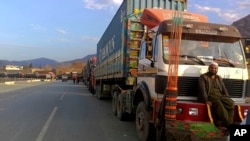 Stranded trucks loaded with supplies for Afghanistan, line up on a highway at the key border crossing point of Torkham in Pakistan along the Afghan border, Feb. 21, 2023.