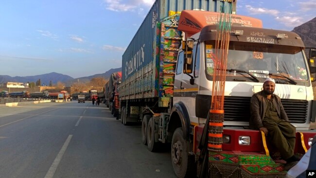 Stranded trucks loaded with supplies for Afghanistan, line up on a highway at the key border crossing point of Torkham in Pakistan along the Afghan border, Feb. 21, 2023.