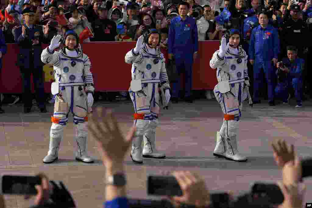 Tiga Astronot China untuk misi Shenzhou-18, dari kanan, Ye Guangfu, Li Cong, dan Li Guangsu, melambaikan tangan saat menghadiri upacara pelepasan misi luar angkasa berawak mereka di Pusat Peluncuran Satelit Jiuquan di China barat laut. (AP)&nbsp;