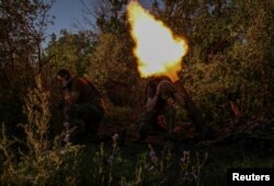 Ukrainian service members fire a mortar at a front line near the city of Bakhmut in Donetsk region, Aug. 7, 2023.