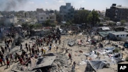 FILE - Palestinians inspect the damage at a site hit by an Israeli bombardment on Khan Younis, southern Gaza Strip, July 13, 2024. The attack reportedly killed Hamas Military Wing Commander Mohammed Deif.