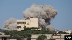 A plume of smoke rises from a building following a reported Russian air strike on Syria's northwestern rebel-held Idlib province, June 25, 2023. 