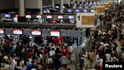 Air Asia passengers queue at counters inside Don Mueang International Airport Terminal 1 amid system outages disrupting the airline's operations, in Bangkok, Thailand, July 19, 2024. 