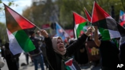 FILE - A woman waves flags in support of Palestinians in Gaza during a protest in Istanbul, April 5, 2024. Turkey and Israel announced tit-for-tat trade barriers, April 9.