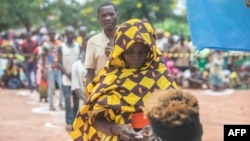 Uma mulher deslocada da província de Cabo Delgado faz fila para receber ajuda humanitária na Escola Tribuna 21 de abril, em Namapa, distrito de Erati, província de Nampula, Moçambique, a 27 de fevereiro de 2024.