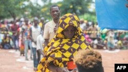 Uma mulher deslocada da província de Cabo Delgado faz fila para receber ajuda humanitária na Escola Tribuna 21 de abril, em Namapa, distrito de Erati, província de Nampula, Moçambique, a 27 de fevereiro de 2024.