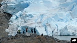 People take in the views of the Mendenhall Glacier on June 8, 2023, in Juneau, Alaska. As the Mendenhall Glacier continues to recede, tourists are flooding into Juneau. (AP Photo/Becky Bohrer)