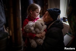 FILE - A grandfather says goodbye to his granddaughter Arina, 6, before her evacuation from front-line city of Bakhmut, amid Russia's attack on Ukraine, in Donetsk region, Ukraine, Jan. 31, 2023.