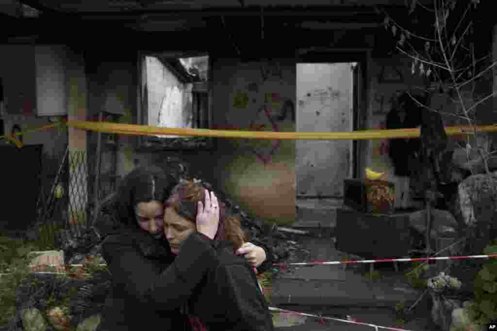 Amit Soussana, 40, right, is hugged by a friend after speaking to reporters in front of her destroyed house in the kibbutz Kfar Azza, near the Gaza Strip, Israel.&nbsp;Soussana was held in captivity for 55 days after being kidnapped during the cross-border attack by Hamas on Oct. 7.