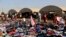 FILE - Displaced Iraqis from the Yazidi community look for clothes to wear among items provided by a charity organization at the Nowruz camp, in Derike, Syria, Aug. 12, 2014. 